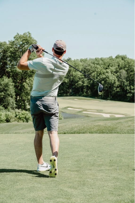 Mann beim Abschlag am Golfplatz