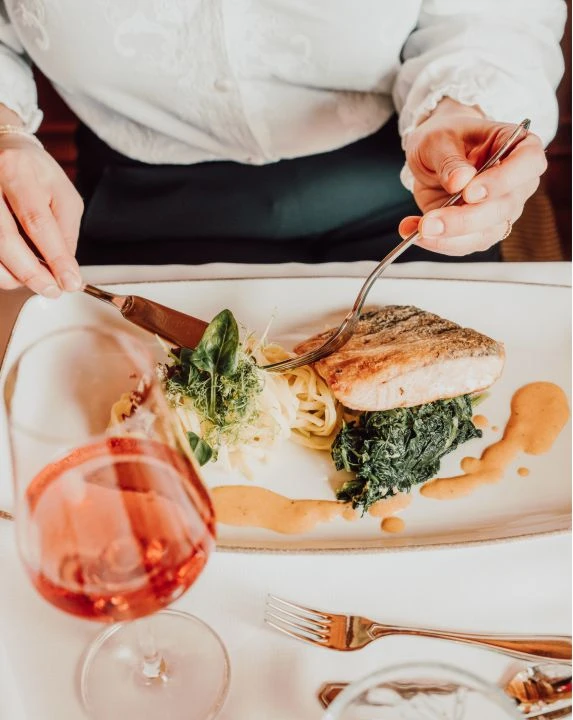 Faulenzer- und Verwöhnpension 8 Frau isst Haupgericht im Restaurant