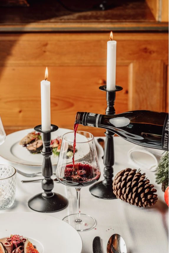Speisekarte & Menüs 4 Rotwein wird am weihnachtlichen Tisch eingeschenkt
