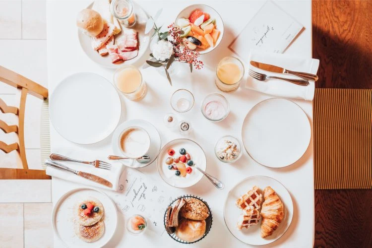 voller Frühstückstisch mit Obst, Saft, Joghurt uvm.