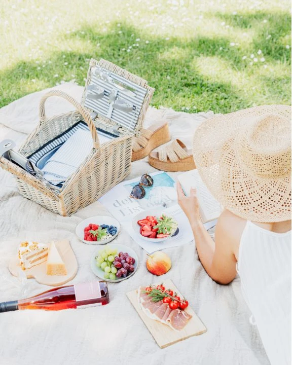 Picknick im Garten mit Beeren, Käse und Herzhaftem