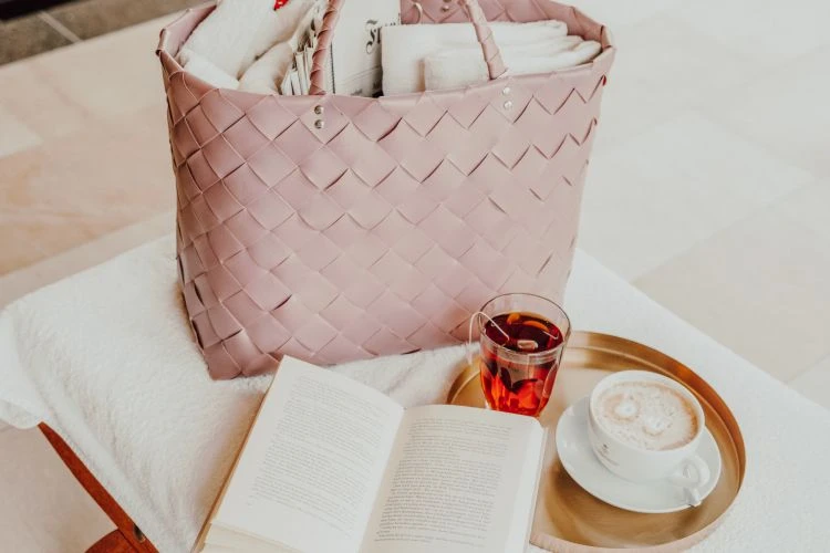 Badekorb auf Liege mit Buch und Kaffee