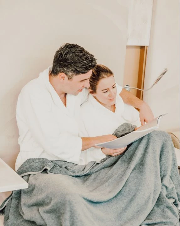 Pärchen in Nischen im Ruheraum mit Wolldecke und Zeitung