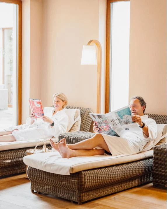 Day Spa 8 Paar im Ruheraum auf Liegen mit Zeitungen