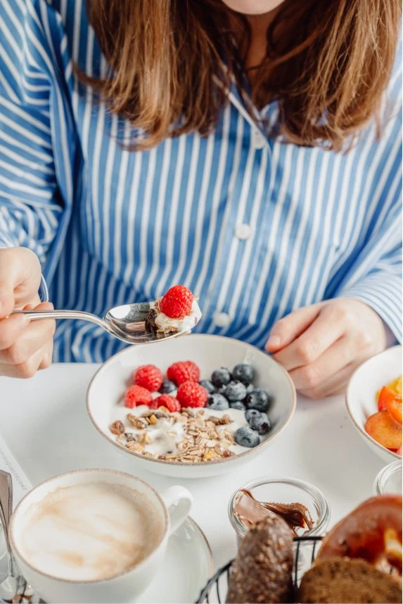 Bett + Bike 4 Frau ist Müsli mit Beeren beim Frühstück