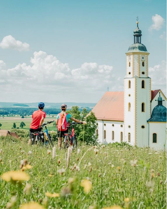 10 Sommer Aktivitäten im Altmühltal 2 Zwei Radfahrer vor Kirche im Altmühltal