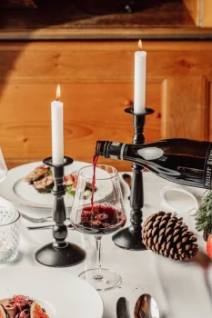 Rotwein wird am weihnachtlichen Tisch eingeschenkt