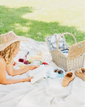 Frau beim lesen eines Buches auf Picknickdecke