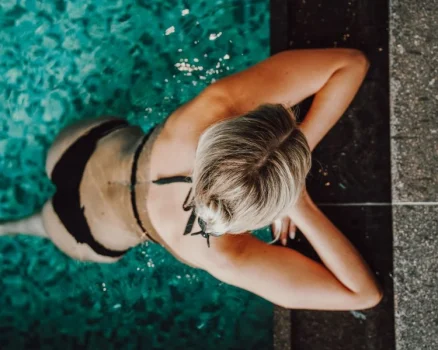 Frau am Poolrand im Badhaus