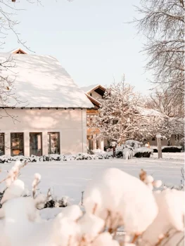 Dein Wellnesshotel: Luxus und Natur vereint 30 verschneite Außenansicht von Badhaus und Hotel