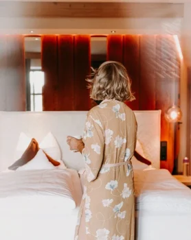 Frau steht vor dem Bett